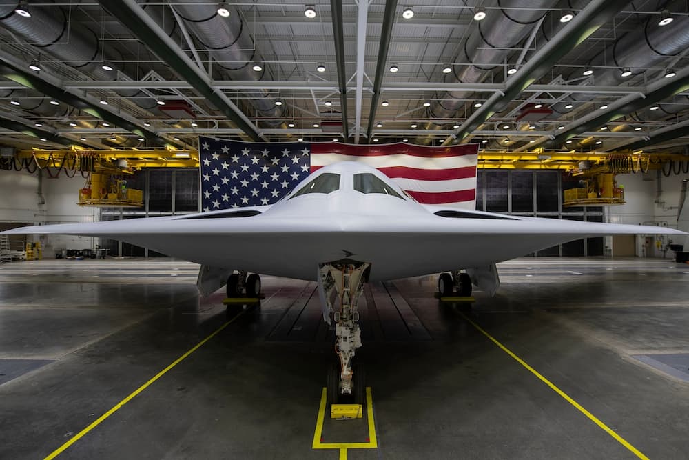 Vista frontal del avión dentro de un hangar con la bandera de los Estados Unidos al fondo