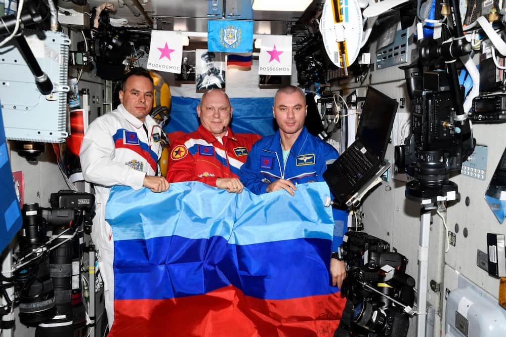 Sergei Korsakov, Oleg Artemyev, y Denis Matveev con la bandera de la República Popular de Lugansk - Roscosmos