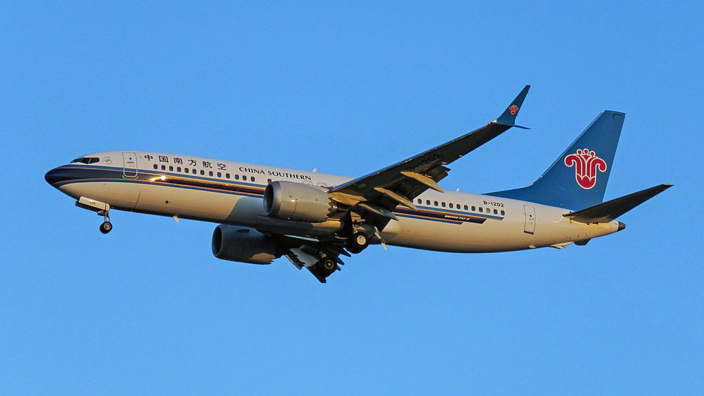 Un 737 MAX de China Eastern aterrizando; en la imagen va de derecha a izquierda y se ve contra el cielo azul