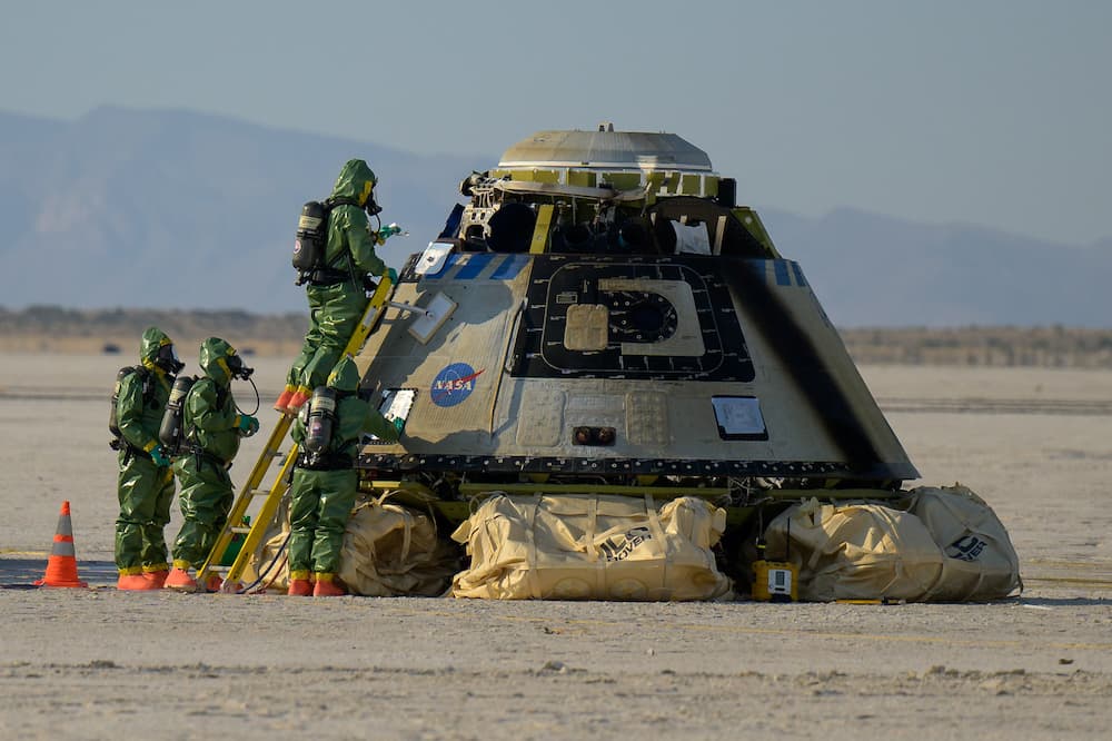 Personal de tierra asegurando la cápsula tras su aterrizaje – NASA/Bill Ingalls