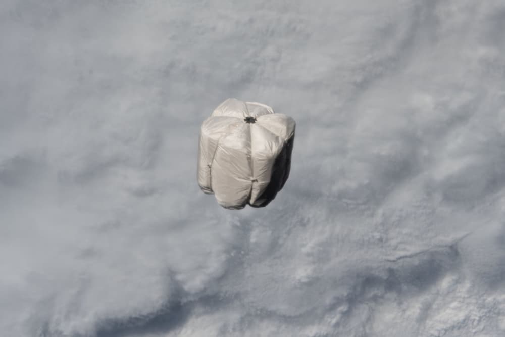 La bolsa de basura expulsada de la EEI fotografiada en el espacio con la Tierra cubierta de nubes al fondo – NASA