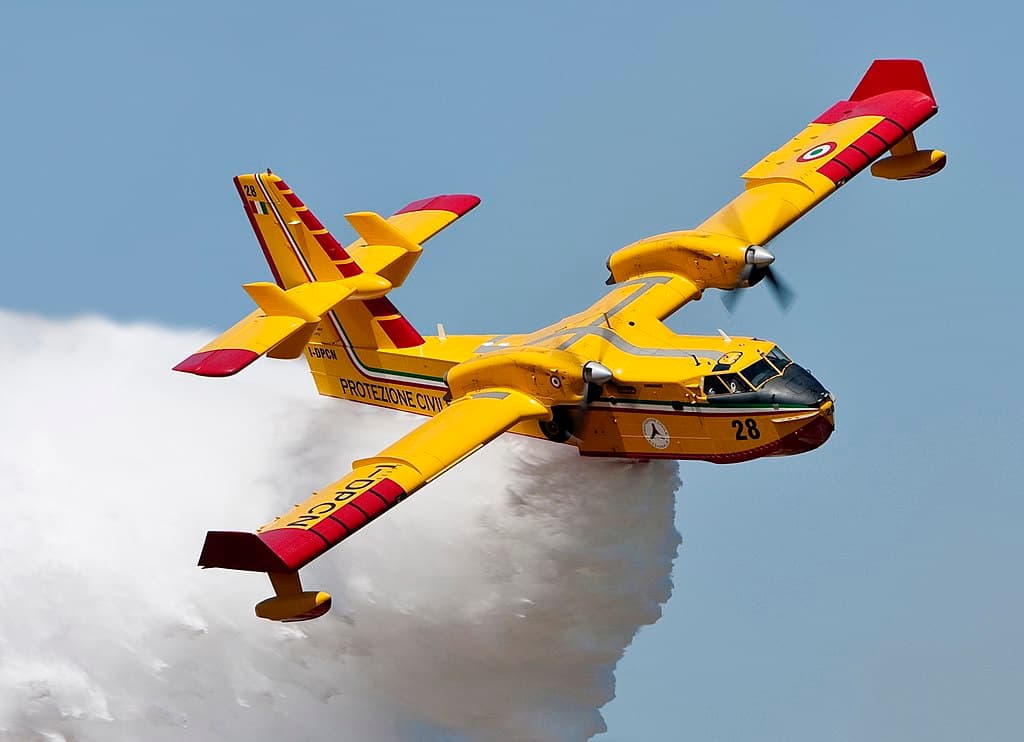 El avión realizando una descarga de agua mientras vira hacia la derecha. Como es habitual en este modelo la pintado en amarillo con detalles en rojo