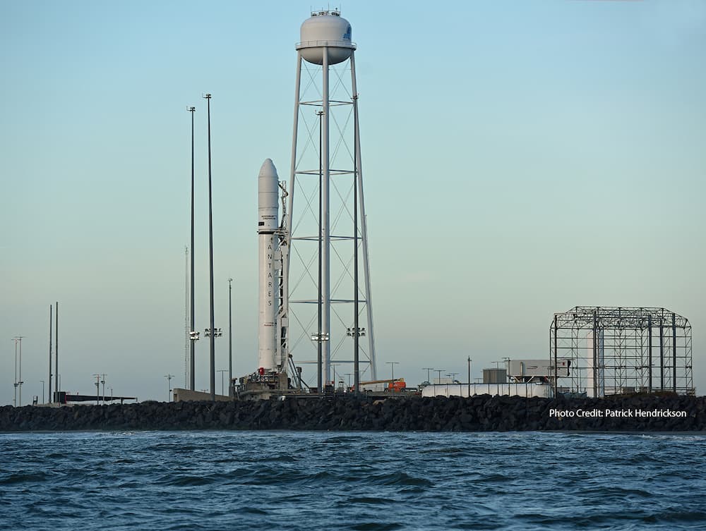 La plataforma de lanzamiento y algunas instalaciones accesorias vistas desde el mar; en ella está el cohete, que en esta perspectiva se ve justo al lado del depósito de agua del sistema de supresión de sonido