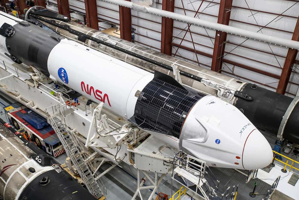 Un Falcon 9 horizontal en el edificio de procesado de vehículos de SpaceX con una Crew Dragon acoplada – SpaceX