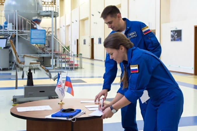 Anna Kikina y Andrei Fedyaev firmando documentación tras haber terminado su formación en Rusia – Roscosmos