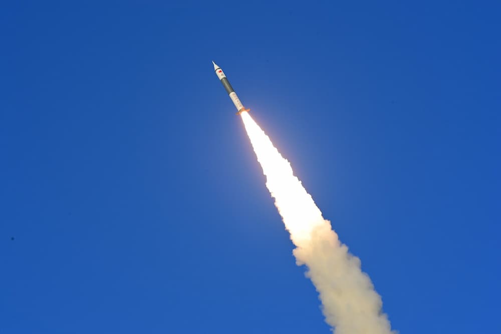 El cohete ya en vuelo atravesando el cuadro de abajo a la derecha hacia arriba a la izquierda contra un cielo azul - CASIC