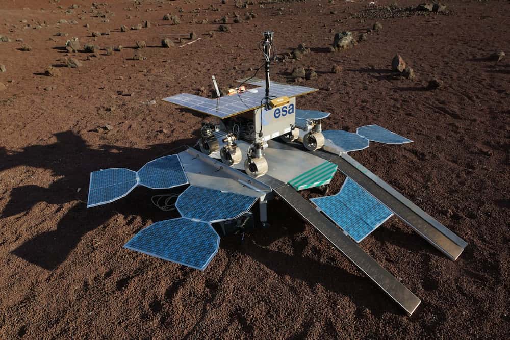 Vista desde arriba y un poco hacia adelante y la izquierda del rover sobre su plataforma de aterrizaje sobre la superficie de Marte