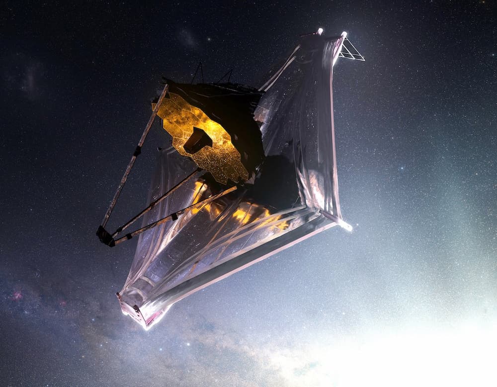 Impresión artística del Webb en el espacio visto desde su lado iluminado por las estrellas, que se reflejan en su espejo principal, con el Sol en la esquina inferior izquierda muy por detrás del telescopio