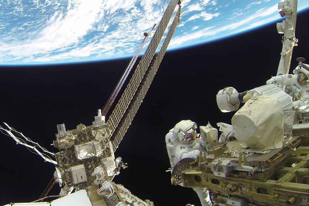 Alneyadi en el exterior de la EEI durante el paseo espacial con la Tierra al fono ocupando el tercio superior de la imagen