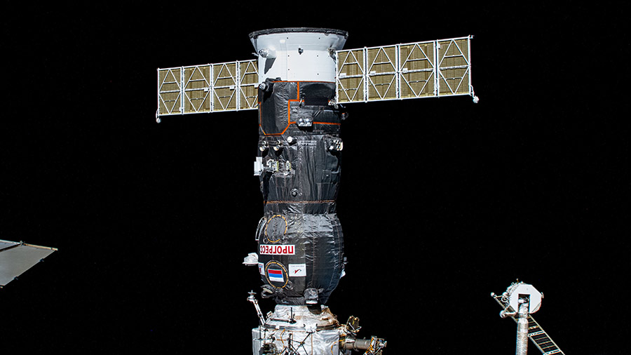 La Progress MS-23 recortada contra el negro del espacio atracada al módulo Poisk de la EEI, cuya parte superior se ve en la parte inferior central de la foto