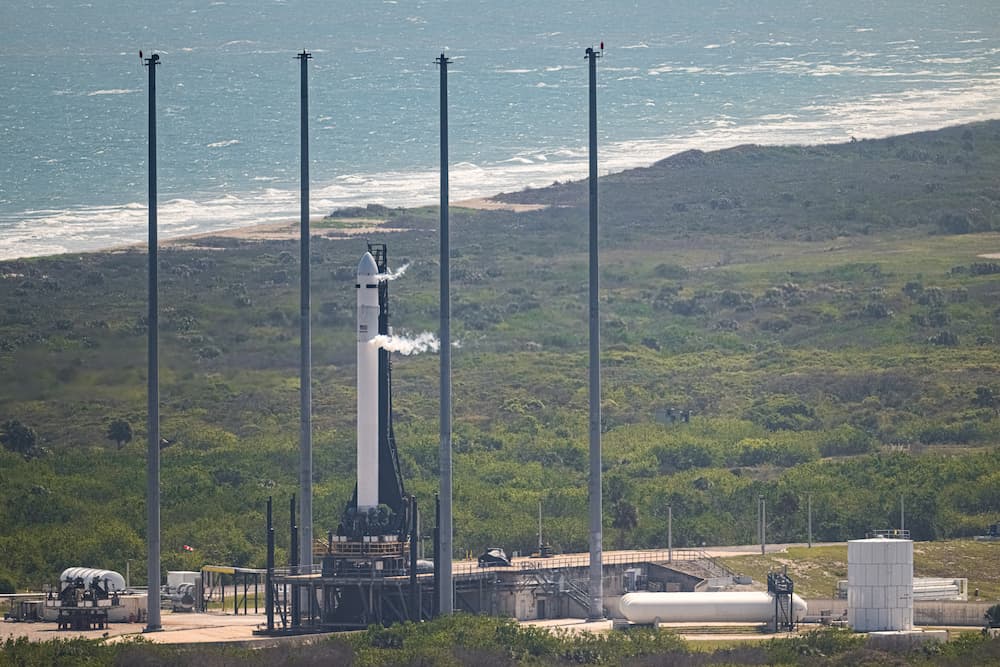 Plano general ligeramente elevado del cohete en la plataforma de lanzamiento expulsando oxígeno gaseoso