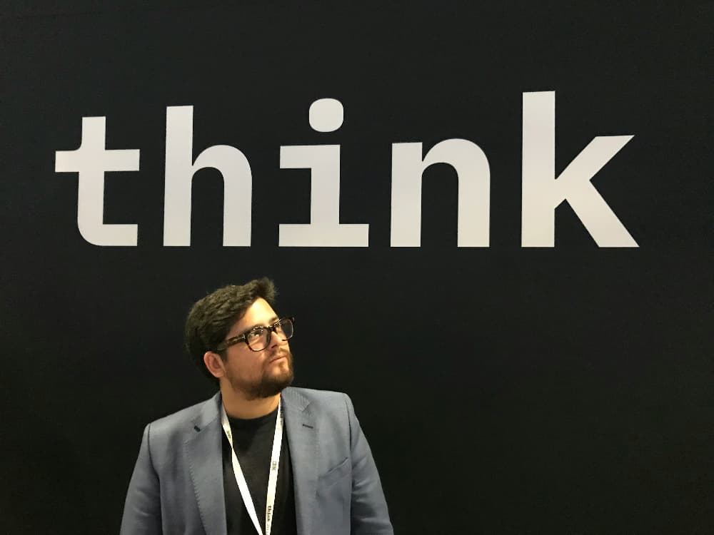 Un tipo delante de un gran rótulo que dice Think