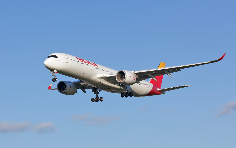 Un A350 a punto de aterrizar visto desde abajo a la derecha con el cielo azul de fondo