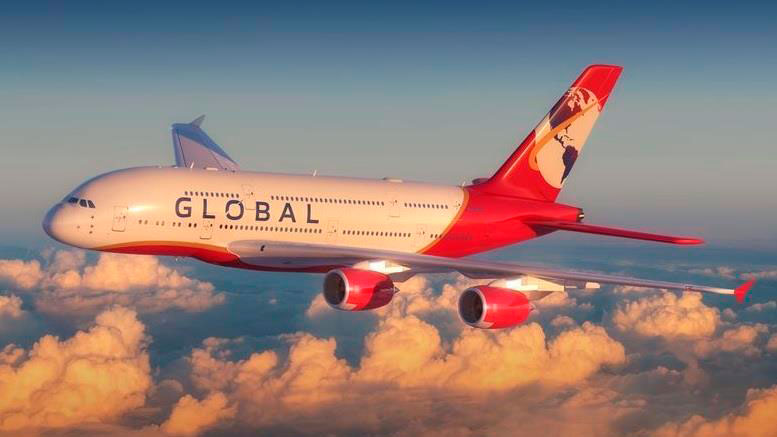 Un A380 con la librea de la aerolínea en vuelo sobre las nubes iluminado por un Sol poniente