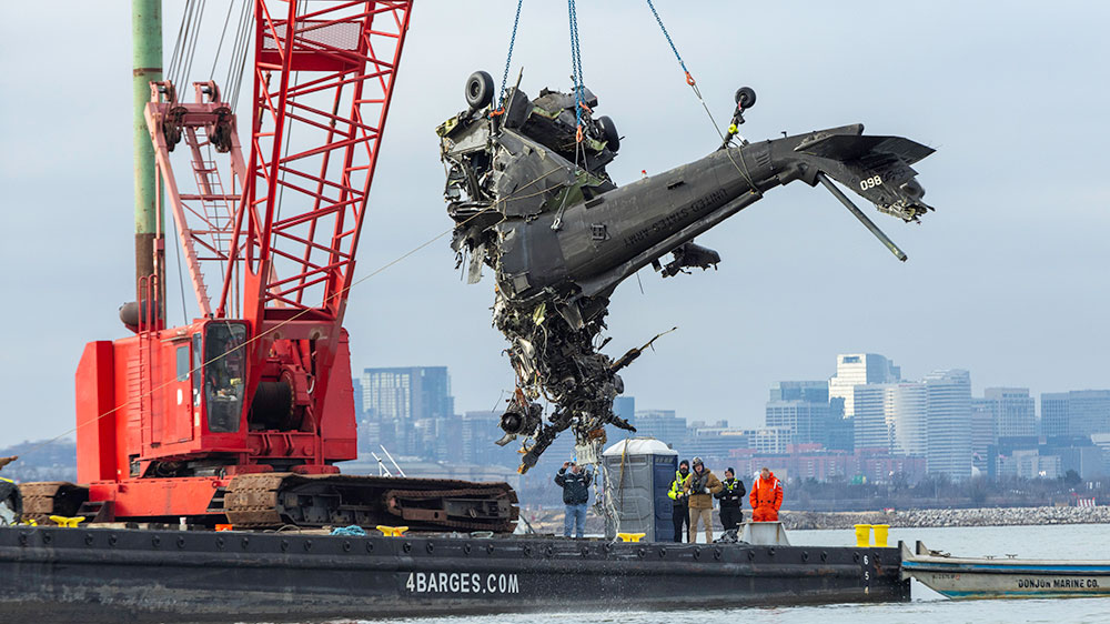 La sección de cola del helicóptero mientras la izan del agua para depositarla en una barcaza