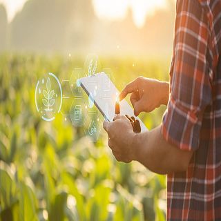 Un tipo manejando una tablet en medio del campo