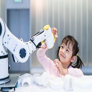 Una niña pequeña interactuando con un robot