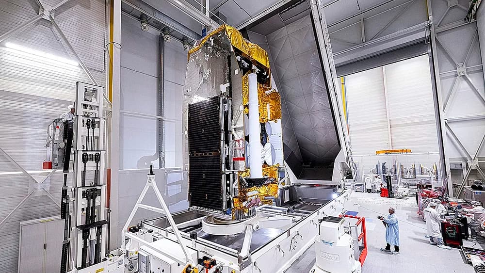 El SpainSat NG I a punto de ser embalado para su envío a Florida para su lanzamiento; salen unas personas en la foto que permiten darse una idea del tamaño