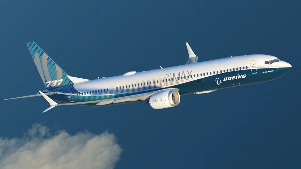 El avión volando frente a un cielo azul con unas pequeñas nubes en la parte inferior del encuadre