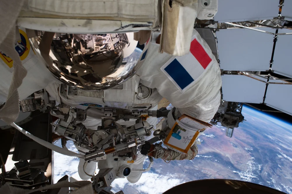 Sophie Adenot en el exterior de la Estación Espacial Internacional con la Tierra al fondo