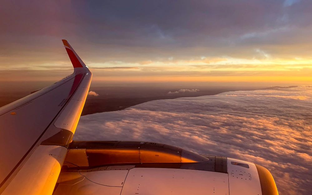 Buenos días Foto tomada a través de la ventanilla de un A320 de Iberia al amanecer en la que se ve el ala rematada en un winglet, así como el motor